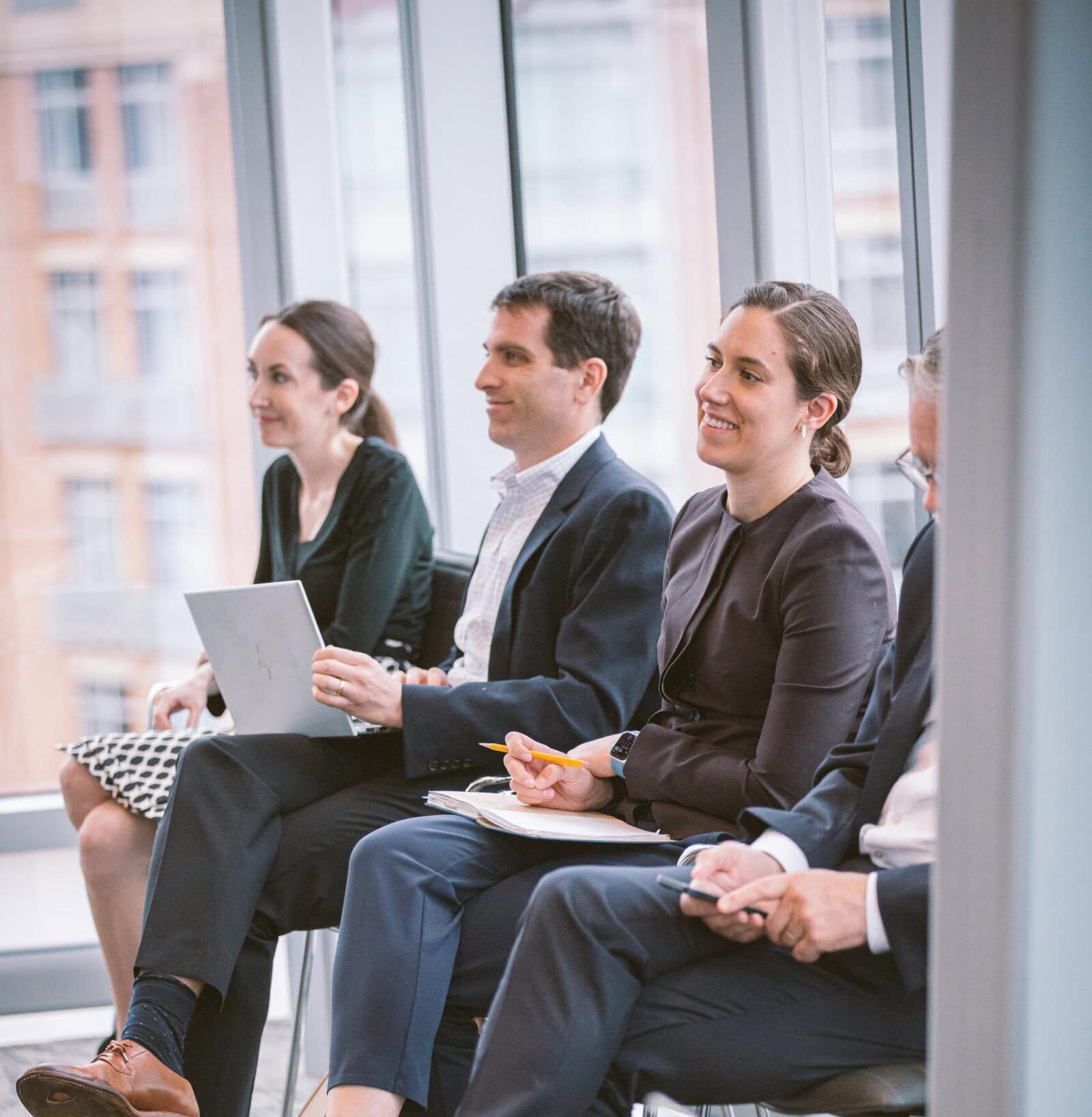 Close up of mixed group of people, smiling and taking notes attending a 4As event