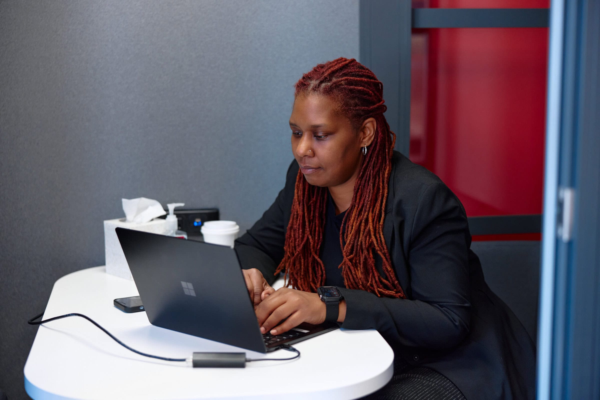 Close up of woman sitting in an office and working on a laptop