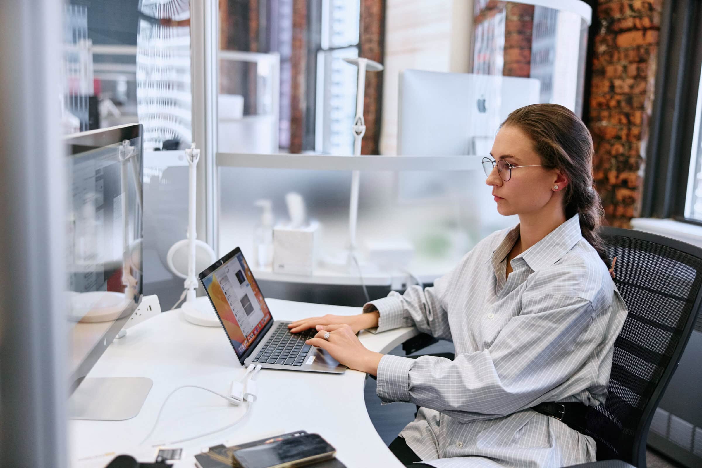 Close up of woman working on a laptop, sitting at a desk