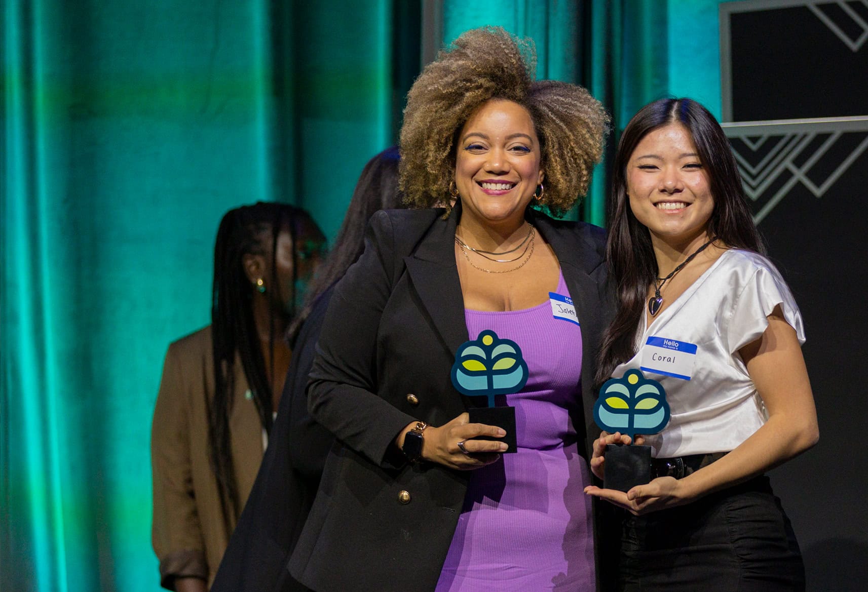 Women holding up award and smiling at camera